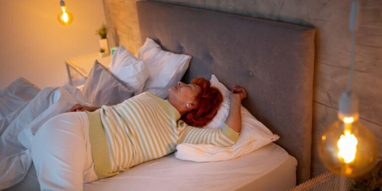 Elderly Woman Stretching In Bed At Memory Care Facility