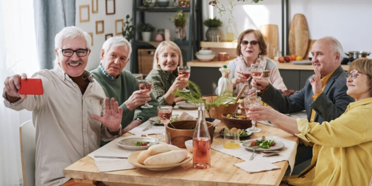 Elderly Friends Toasting Around Shared Dining Table at Independent Facility